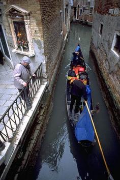 A gondola passing thru a very small canal in Venice, Italy