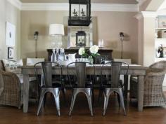 
                    
                        A reclaimed lumber table is mixed with metal Tolix chairs and wicker chairs to create an informal, relaxed dining room. Designer tip: You don't have to buy a dining set. Mix it up with different chairs.
                    
                
