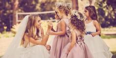 Bride kneeling by flower girls holding babys breath