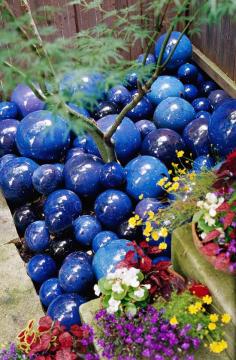 Embrace the Unexpected in Your Garden. Add some whimsy, here a "mulch" of blue glazed ceramc balls brightens up the base of a Japanese maple.