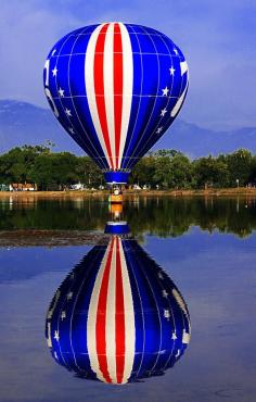 76 Stars and Stripes, Red, White, & Blue Hot Air Balloon Dipping in Prospect Lake, Memorial Park, Colorado Balloon Classic, United States.
