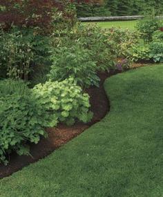 Perfect Edging -  Using an edger, cut your initial line, and then pull out the clumps by hand.  See how it is done in this article.  Done monthly, it will keep your yard from having the ragged edge look.