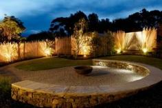 The softly undulating rear yard is landscaped in a typically Australian coastal style.A large steel Japanese cauldron is a simple but strong focal point for