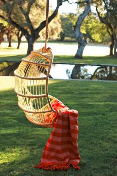 Love these little hanging chairs for backyards; I could just curl up with that blanket and read a book