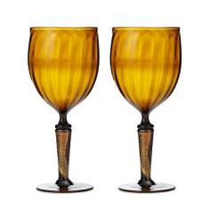 
                    
                        The amber glass goblets are upcycled from the necks of four beer bottles which Soderberg cuts to size, heats in a kiln to make them pliable enough to reshape, and heat-fuses gestural strokes of gold leaf to the surface of the stems
                    
                